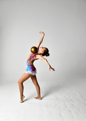 girl in gymnastic suit with golden ball
