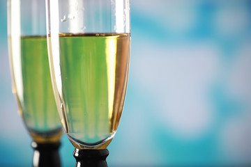 Background with tall glasses for sparkling wines. Champagne and spray in glass glasses. Celebratory drink with reflection.