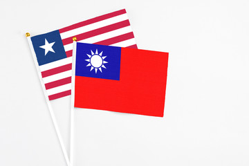 Fototapeta premium Taiwan and Liberia stick flags on white background. High quality fabric, miniature national flag. Peaceful global concept.White floor for copy space.