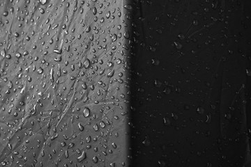 Water drops on waterproof nylon fabric. Macro detail view of texture of blue woven synthetic waterproof clothing. morning dew on camping tent close view. Rain, Black and white