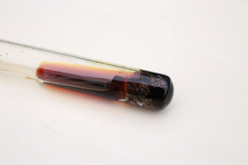 The chemical process of dissolving metallic iron in nitric acid, in test tube, with the formation...