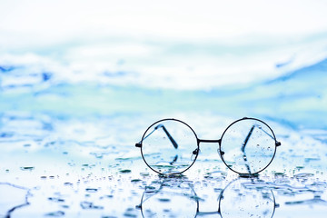 Tools for vision correction. Glasses and lenses with diopters on the background of splashes and...