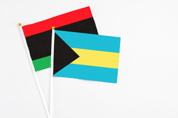 Bahamas and Libya stick flags on white background. High quality fabric, miniature national flag....