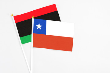 Chile and Libya stick flags on white background. High quality fabric, miniature national flag. Peaceful global concept.White floor for copy space.