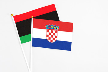 Croatia and Libya stick flags on white background. High quality fabric, miniature national flag....