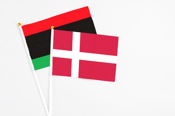 Denmark and Libya stick flags on white background. High quality fabric, miniature national flag. Peaceful global concept.White floor for copy space.