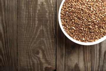 Buckwheat in a light bowl on a rustic background top view copy space.