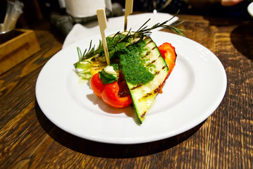 Vegetarian dish, baked vegetables. Pepper, zucchini, corn and a sprig of rosemary