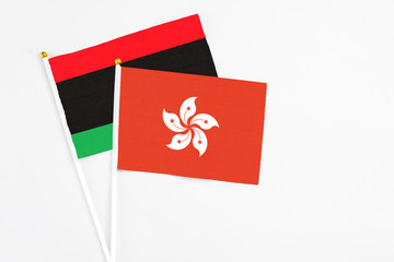 Hong Kong and Libya stick flags on white background. High quality fabric, miniature national flag. Peaceful global concept.White floor for copy space.