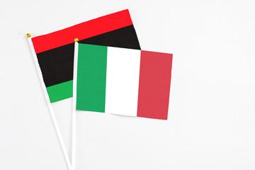 Italy and Libya stick flags on white background. High quality fabric, miniature national flag....