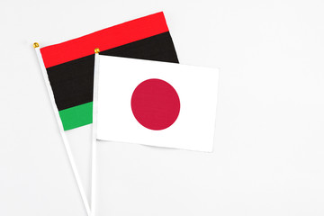 Japan and Libya stick flags on white background. High quality fabric, miniature national flag....