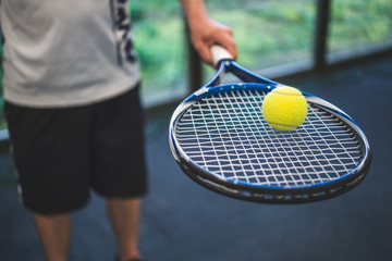 Guy balancing a tennis ball on a racket