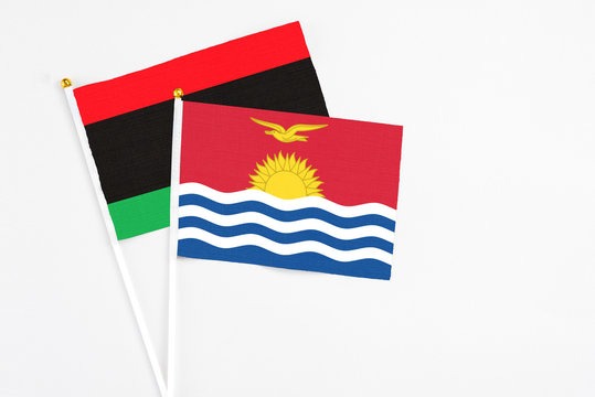 Kiribati and Libya stick flags on white background. High quality fabric, miniature national flag. Peaceful global concept.White floor for copy space.
