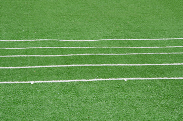 Fototapeta na wymiar white line as running lane on the green grass
