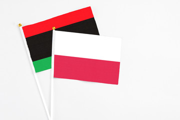 Poland and Libya stick flags on white background. High quality fabric, miniature national flag....