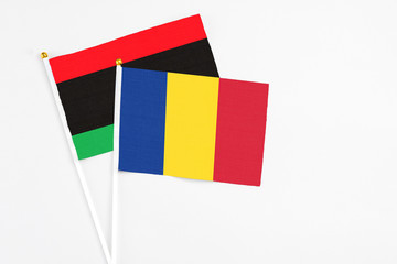 Romania and Libya stick flags on white background. High quality fabric, miniature national flag. Peaceful global concept.White floor for copy space.