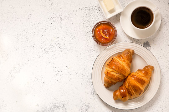 breakfast with croissants. fresh crispy croissants and coffee on a light .background, top view..
