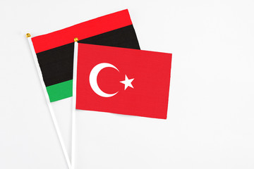 Turkey and Libya stick flags on white background. High quality fabric, miniature national flag. Peaceful global concept.White floor for copy space.