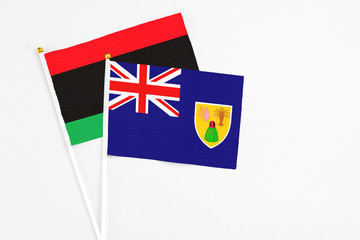 Turks And Caicos Islands and Libya stick flags on white background. High quality fabric, miniature...