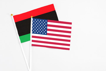 United States and Libya stick flags on white background. High quality fabric, miniature national...