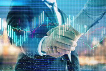 Double exposure of financial chart on cityscape background with two businessmen handshake. Concept of financial analysis and investment opportunities