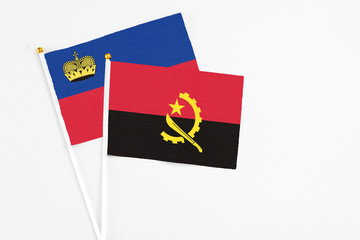 Angola and Liechtenstein stick flags on white background. High quality fabric, miniature national...