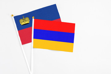 Armenia and Liechtenstein stick flags on white background. High quality fabric, miniature national flag. Peaceful global concept.White floor for copy space.