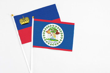 Belize and Liechtenstein stick flags on white background. High quality fabric, miniature national flag. Peaceful global concept.White floor for copy space.