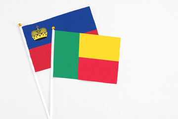 Benin and Liechtenstein stick flags on white background. High quality fabric, miniature national flag. Peaceful global concept.White floor for copy space.