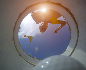 view of bottom low angle of the golf hole, hand of woman golf player going to takes a golf ball...