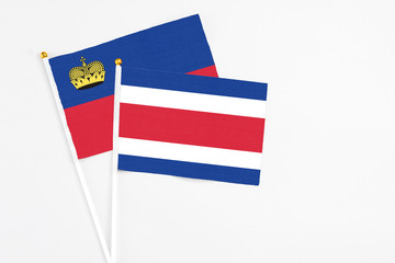 Costa Rica and Liechtenstein stick flags on white background. High quality fabric, miniature national flag. Peaceful global concept.White floor for copy space.