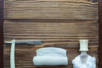 Shaving accessories on a wooden texture background. Tools. Disposable shaving machine, brush, foam and hazard razor.