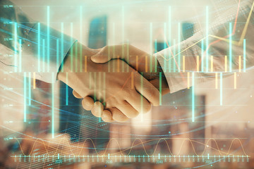 Double exposure of financial graph on cityscape background with two businessman handshake. Concept of stock market deal