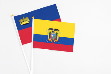 Ecuador and Liechtenstein stick flags on white background. High quality fabric, miniature national flag. Peaceful global concept.White floor for copy space.