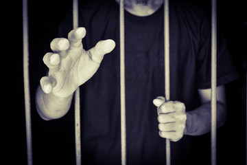 hand man reach out and hold steel in jail on black background.concept for...