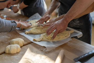 Culinary master class. Closeup of people hands preparing khachapuri. Traditional georgian cheese bread. Georgian food