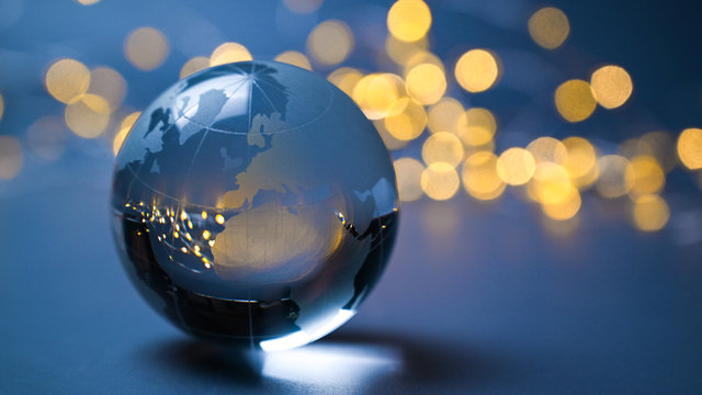 2022 new year Europe and africa, asian, on a earth ball in front of golden lights and chain lights above a blue abstract background. Stars of global economy.