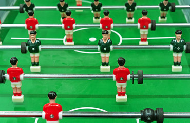 Table football with red and green players on the field.