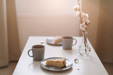 Piece of apple pie on plate with cup of coffee on white table. Breakfast with coffee and cake in cafe. food photography. 