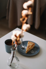 Piece of apple pie on plate with cup of coffee on white table. Breakfast with coffee and cake in cafe. food photography. 