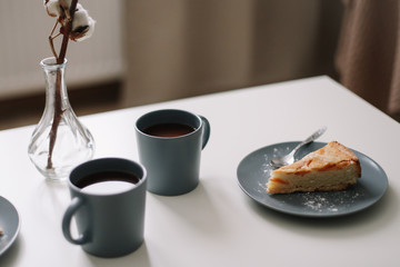 Piece of apple pie on plate with cup of coffee on white table. Breakfast with coffee and cake in cafe. food photography. 