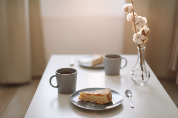 Piece of apple pie on plate with cup of coffee on white table. Breakfast with coffee and cake in cafe. food photography. 