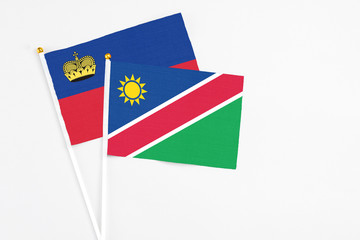 Namibia and Liechtenstein stick flags on white background. High quality fabric, miniature national flag. Peaceful global concept.White floor for copy space.