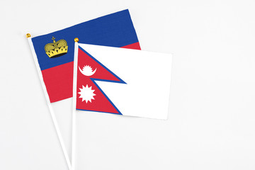 Nepal and Liechtenstein stick flags on white background. High quality fabric, miniature national flag. Peaceful global concept.White floor for copy space.