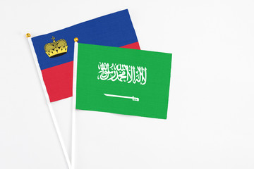Saudi Arabia and Liechtenstein stick flags on white background. High quality fabric, miniature national flag. Peaceful global concept.White floor for copy space.