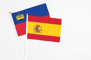 Spain and Liechtenstein stick flags on white background. High quality fabric, miniature national flag. Peaceful global concept.White floor for copy space.