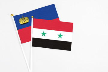 Syria and Liechtenstein stick flags on white background. High quality fabric, miniature national flag. Peaceful global concept.White floor for copy space.