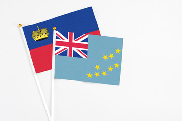 Fototapeta premium Tuvalu and Liechtenstein stick flags on white background. High quality fabric, miniature national flag. Peaceful global concept.White floor for copy space.