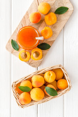 Friut background with apricot jam on white wooden background top view