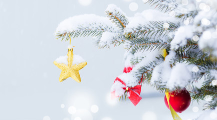 Christmas tree in snow background. New Year composition with fir tree, balls and lights and bokeh.